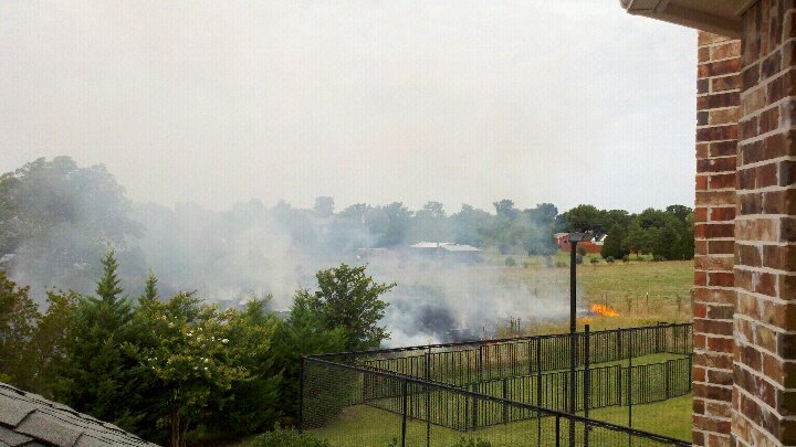A wildfire burns freely in an open pasture.