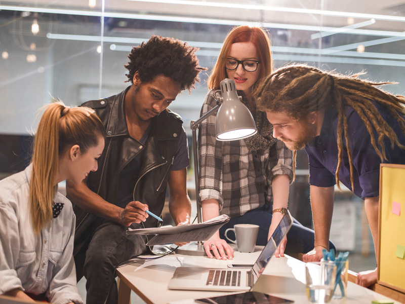 Photo of a person showcasing a notebook to their team.