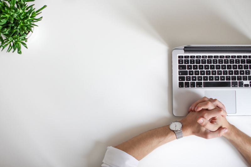 Overhead photo of a man waiting in front of his laptop