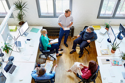 Simpli5 helps leaders understand and unite their company cultures. Photo of a team discussing a merger.